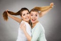 Two happy friends women hugging holding hair Royalty Free Stock Photo