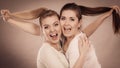 Two happy friends women hugging holding hair Royalty Free Stock Photo