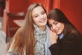 Two happy girl friends talking and drinking coffee in autumn city in cafe. Meeting of good friends, young fashionable students Royalty Free Stock Photo