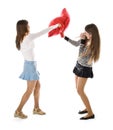 Two happy girlfriends fighting a pillows