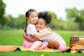 Two happy girls as friends hug each other in cheerful way. Little girlfriends in park. Childhood, family, love, friendship and