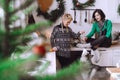 Two happy girls friends or sisters with white husky dog in Christmas decorations on the kitchen Royalty Free Stock Photo