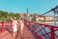 happy girls friends walking on Saint Georges pedestrian bridge while traveling in Lyon old town in France