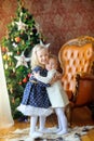 Two happy girls hugging and smiling standing near the Christmas tree Royalty Free Stock Photo