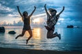 Two happy girls jumping at sunset on tropical beach Royalty Free Stock Photo