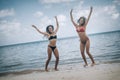 Two happy girls jumping on a tropical beach Royalty Free Stock Photo