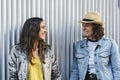 Two happy girls looking each other and smiling in metallic and clean background Royalty Free Stock Photo