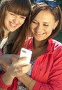Two happy girls with mobile phone Royalty Free Stock Photo