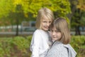 Two happy girls are playing in the autumn park. Smiling and hugging Royalty Free Stock Photo