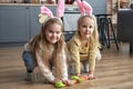 Two happy girls playing handmade carrots on the floor