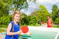 Two happy girls playing ping pong outside