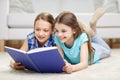 Two happy girls reading book at home Royalty Free Stock Photo