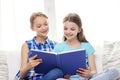 Two happy girls reading book at home Royalty Free Stock Photo