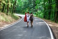 Two happy girls in a road hitchhiking with backpack and guitar