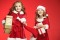 Two happy girls in santa claus hats with gift boxes Royalty Free Stock Photo