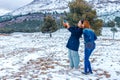 Two happy girls of Slavic appearance, brunette and red-haired, make a selfie on a smartphone, outdoors in the winter