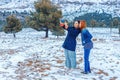 Two happy girls of Slavic appearance, brunette and red-haired, make a selfie on a smartphone, outdoors in the winter