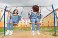 Two happy girls are swinging on a swing, laughing Royalty Free Stock Photo