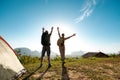 Two happy hikers with raised arms at sunrise