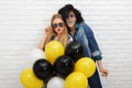 Two happy hipster girls in sunglasses have fun with balloons Royalty Free Stock Photo