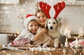 Two happy kids with dog golden retriever puppy in kitchen, making Christmas cookies at home Royalty Free Stock Photo