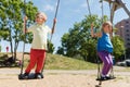 Two happy kids swinging on swing at playground Royalty Free Stock Photo