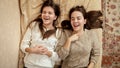 Two happy laughing girls relaxing on bed and talking. Teenager friendship and relationship Royalty Free Stock Photo