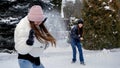 Two happy laughing teenage girls playing snowballs in backyard on snowy winter day. People playing outdoors, winter holidays and Royalty Free Stock Photo
