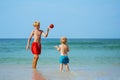 Two happy little boys play with the ball standing in sea Royalty Free Stock Photo