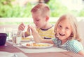 Two happy little children eating healthy breakfast at home Royalty Free Stock Photo