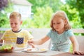 Two happy little children eating healthy breakfast at home