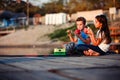 Two happy little friends, boy and girl talking, drinking tea, eating sandwiches and fishing on a lake in a sunny summer day Royalty Free Stock Photo