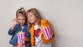 two happy little girls eating sweet popcorn with dragee Royalty Free Stock Photo