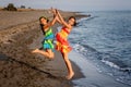 Two happy little girls jumping in the air on the beach Royalty Free Stock Photo