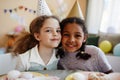 Two happy little girls looking at camera while enjoying birthday party Royalty Free Stock Photo