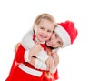 Two happy little girls in santa suits embracing Royalty Free Stock Photo