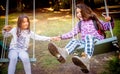 Two happy little girls swinging on the swing Royalty Free Stock Photo