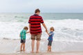 Two little kids boys and father on the beach of ocean Royalty Free Stock Photo