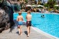 Two happy little kids boys jumping in the pool and having fun on family vacations in a hotel resort. Healthy children Royalty Free Stock Photo