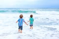 Two happy little kids boys running on the beach of ocean. Funny cute children, sibling and best friends making vacations Royalty Free Stock Photo