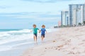 Two happy little kids boys running on the beach of ocean. Funny cute children, sibling and best friends making vacations Royalty Free Stock Photo