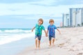 Two happy little kids boys running on the beach of ocean. Funny cute children, sibling and best friends making vacations Royalty Free Stock Photo