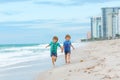 Two happy little kids boys running on the beach of ocean. Funny cute children, sibling and best friends making vacations Royalty Free Stock Photo
