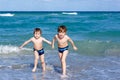 Two kid boys running on ocean beach. Little children having fun Royalty Free Stock Photo