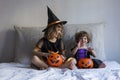 two happy little sisters having fun at home wearing halloween costumes and pumpkins. Trick or treat. Home, indoors. Lifestyle Royalty Free Stock Photo