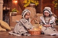 Two happy little sisters in retro outfits play with ducklings. Country style. Easter Royalty Free Stock Photo