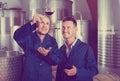 Two happy men coworkers wearing uniform standing with glass of w Royalty Free Stock Photo