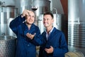 Two happy men coworkers wearing uniform standing with glass of wine Royalty Free Stock Photo