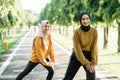 two happy Muslim girls in headscarves do lunges before jogging