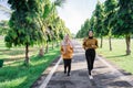 two happy Muslim girls in headscarves do outdoor sports while jogging together